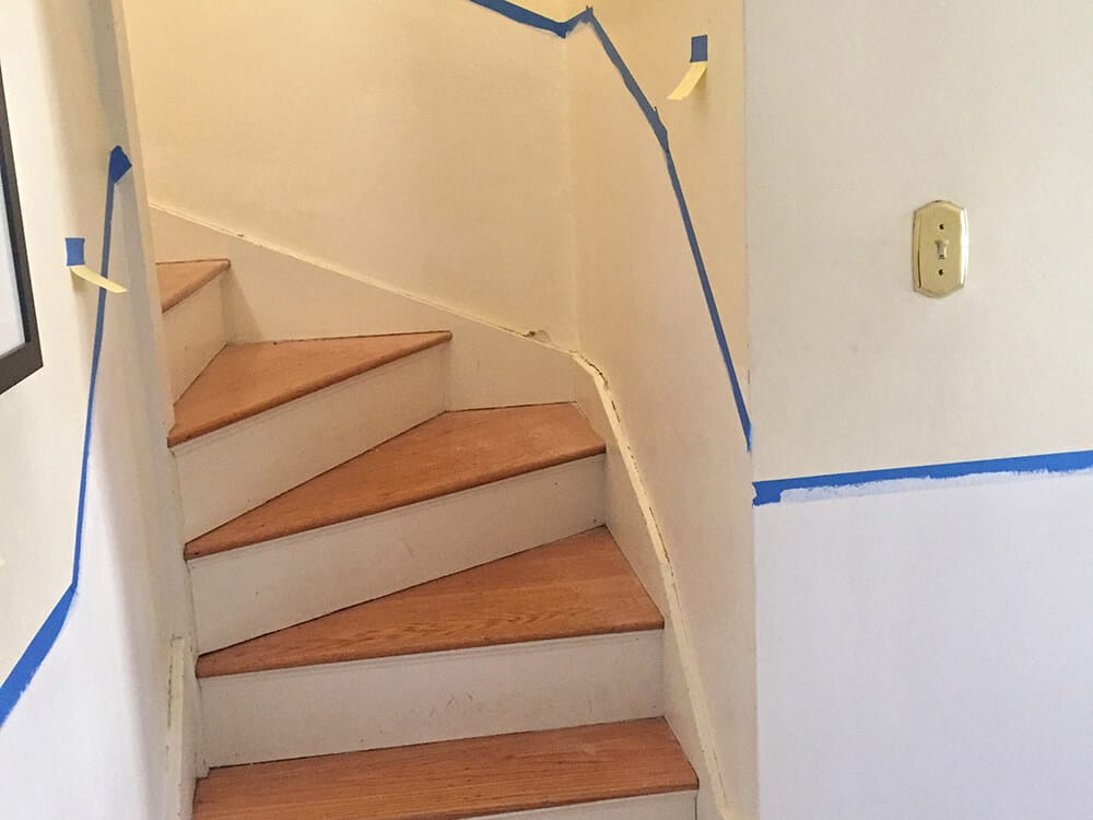 We started by laying out the chair rail with masking tape, following the pitch of the stairs.