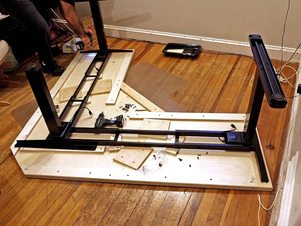 Attaching the motorized stand to the desk top.