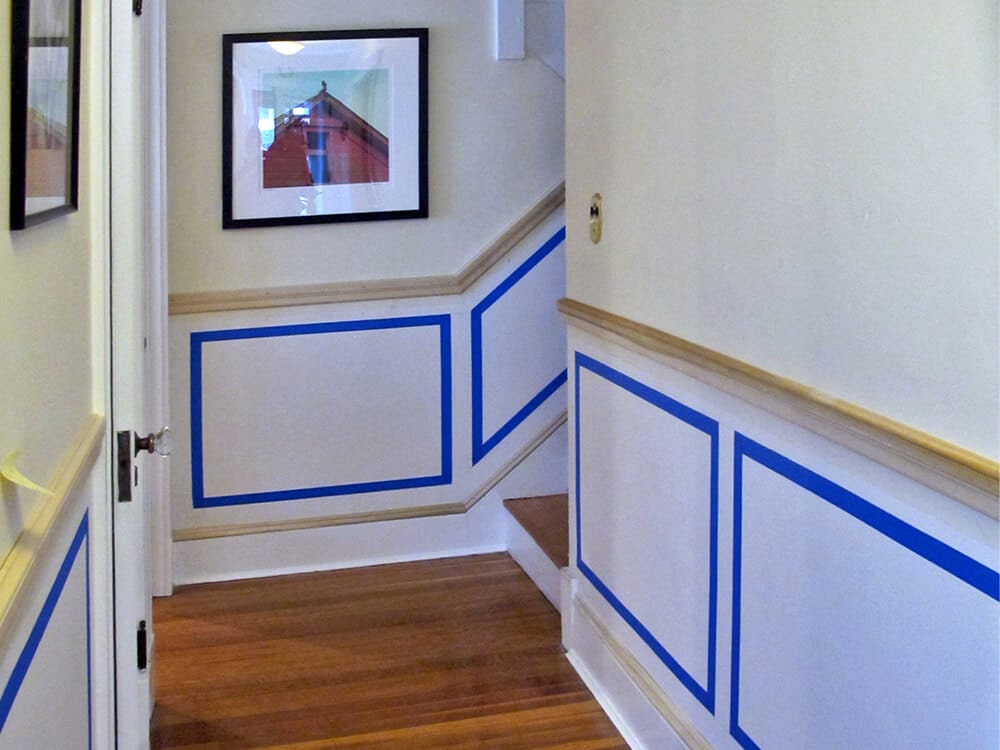The chair rail is installed. Masking tape helps us to visualize the proportions of the picture frames.