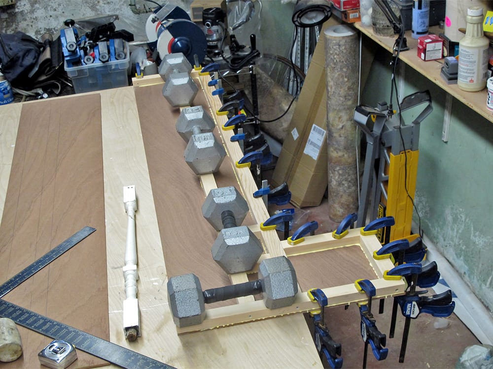 The shelf faces are glued to the frames, and held under pressure with dumbbells.